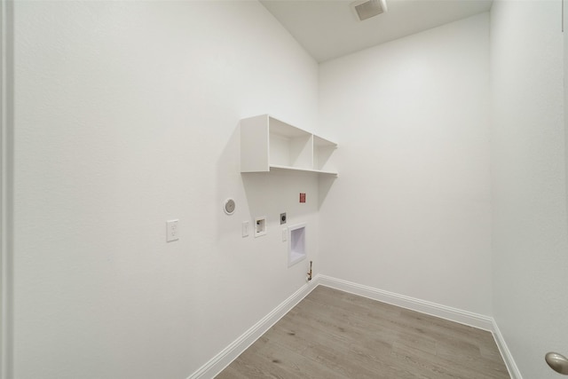 clothes washing area with hookup for an electric dryer, laundry area, light wood finished floors, gas dryer hookup, and visible vents
