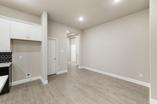 kitchen featuring baseboards, light countertops, recessed lighting, light wood-style floors, and white cabinets