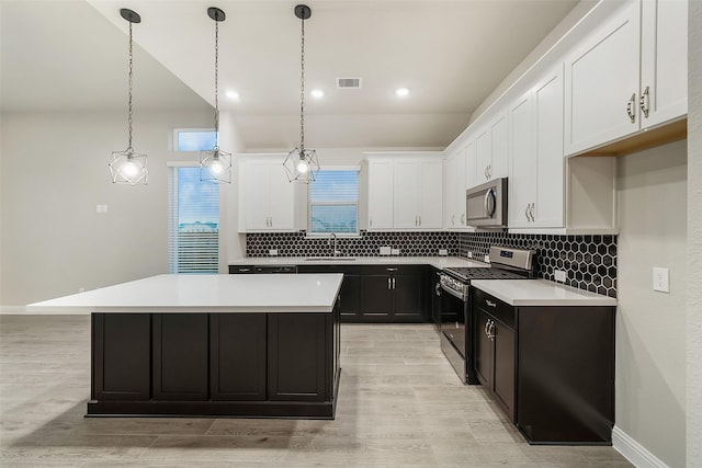 kitchen featuring visible vents, white cabinets, appliances with stainless steel finishes, tasteful backsplash, and a center island