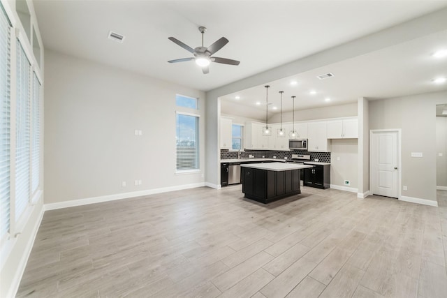 kitchen with stainless steel appliances, tasteful backsplash, visible vents, and open floor plan