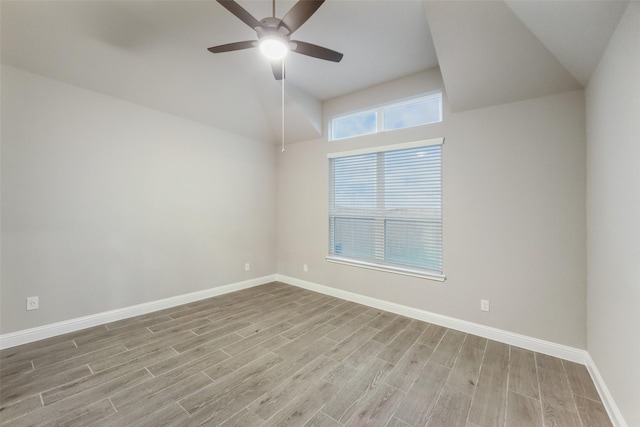 empty room with lofted ceiling, wood finished floors, baseboards, and ceiling fan