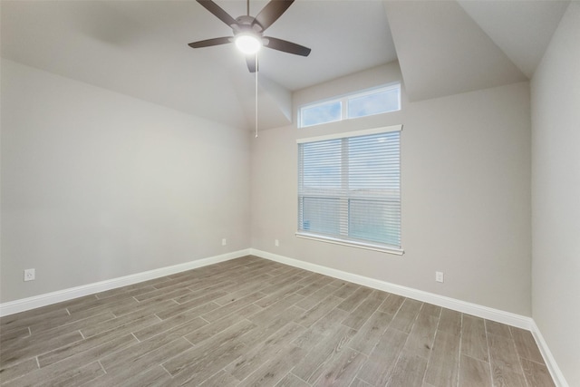 spare room featuring ceiling fan, baseboards, lofted ceiling, and wood finished floors