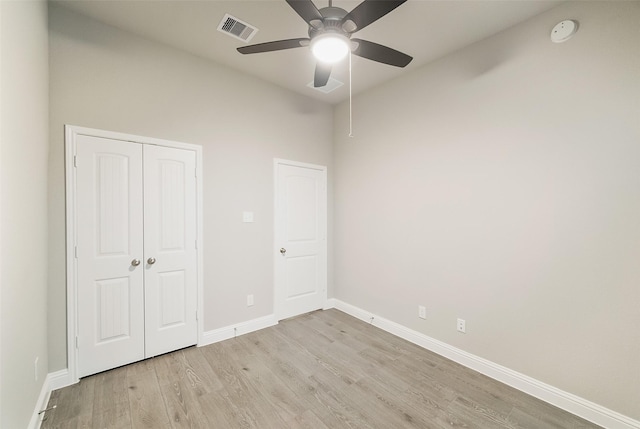 unfurnished bedroom featuring light wood-type flooring, visible vents, a ceiling fan, a closet, and baseboards