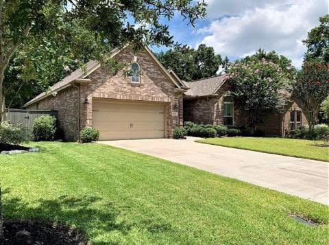 view of front of property featuring brick siding, a front lawn, an attached garage, and driveway