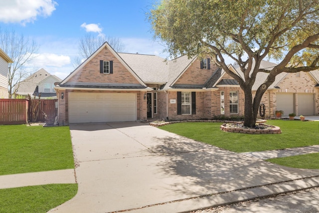 traditional-style house featuring brick siding, concrete driveway, a front yard, and fence