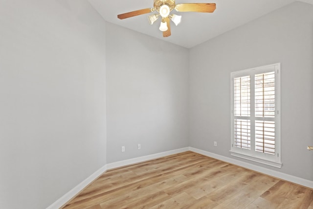 unfurnished room with a wealth of natural light, a ceiling fan, baseboards, and wood finished floors