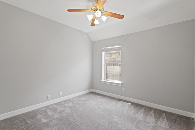 carpeted spare room with lofted ceiling, a ceiling fan, and baseboards