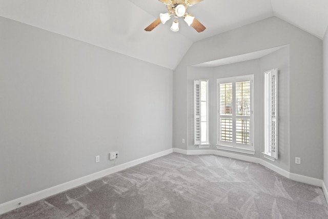 carpeted empty room featuring baseboards, a ceiling fan, and vaulted ceiling