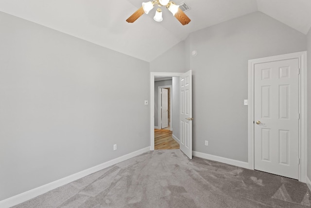 unfurnished bedroom featuring a ceiling fan, carpet, visible vents, baseboards, and vaulted ceiling