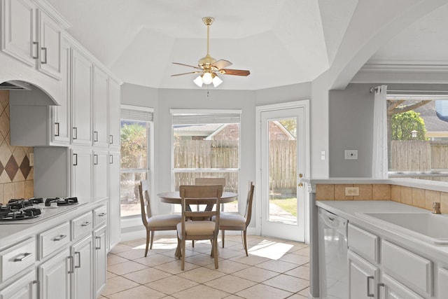 kitchen with a wealth of natural light, tasteful backsplash, white cabinetry, white appliances, and light countertops