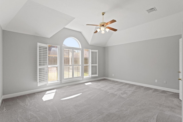 unfurnished room featuring visible vents, a ceiling fan, baseboards, carpet, and lofted ceiling