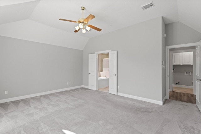 unfurnished bedroom with light carpet, visible vents, baseboards, and lofted ceiling