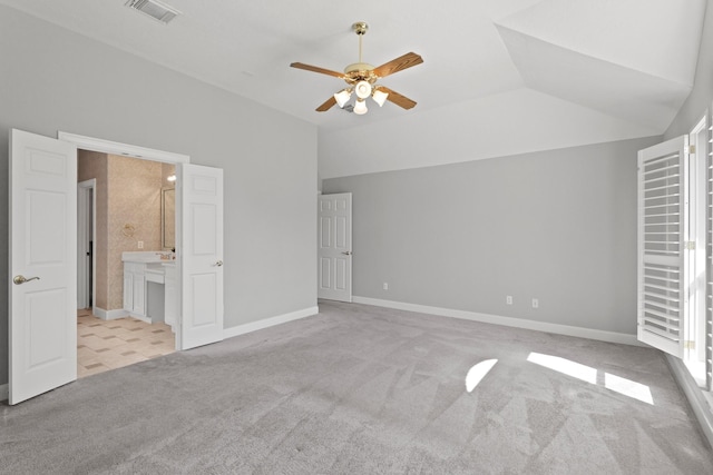 unfurnished bedroom featuring vaulted ceiling, carpet flooring, baseboards, and visible vents