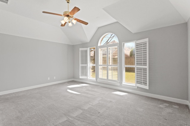 spare room featuring baseboards, carpet flooring, and vaulted ceiling