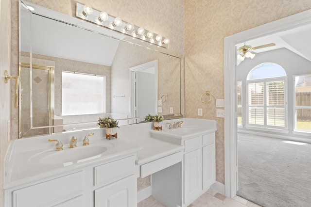 bathroom featuring a sink, lofted ceiling, double vanity, and wallpapered walls