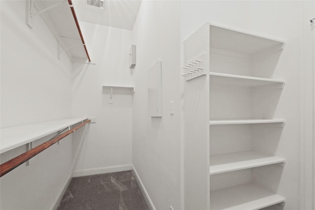 walk in closet featuring visible vents and dark colored carpet