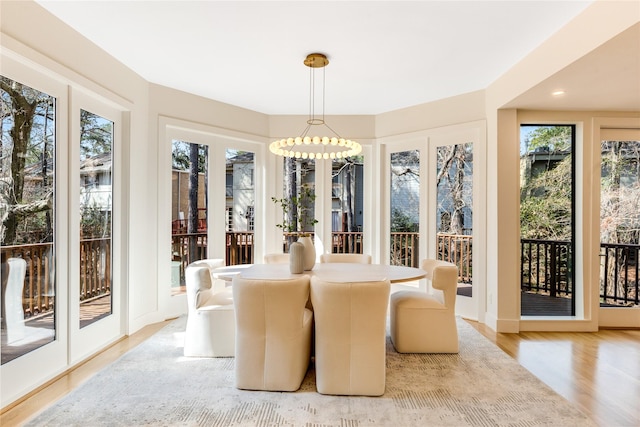 sunroom / solarium with a notable chandelier