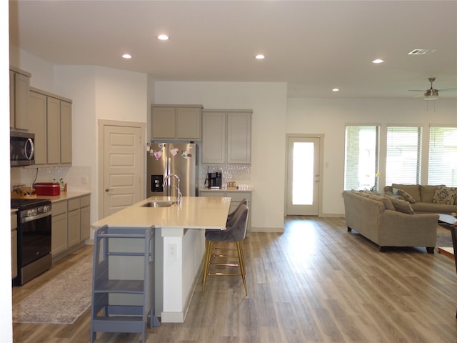 kitchen featuring a sink, light countertops, gray cabinetry, and stainless steel appliances