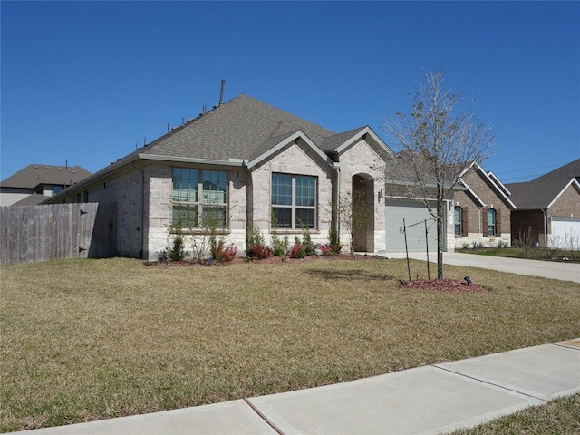 view of front of property with concrete driveway, brick siding, a front yard, and roof with shingles