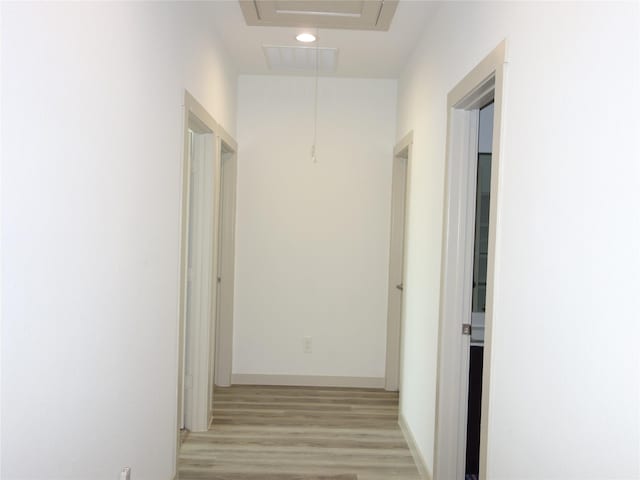 corridor with baseboards and light wood-style floors