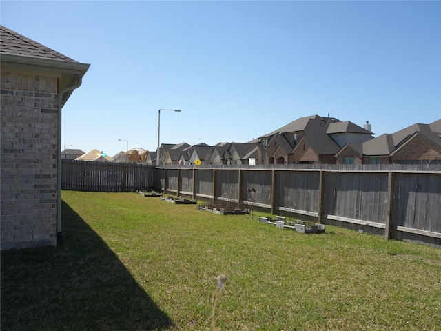 view of yard with a residential view and a fenced backyard