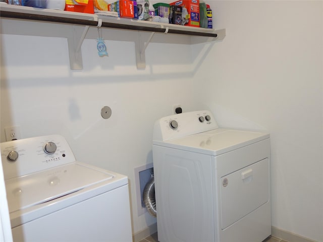 clothes washing area with baseboards, laundry area, and washing machine and clothes dryer