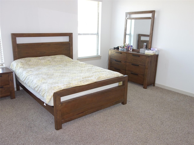 bedroom with baseboards and light carpet