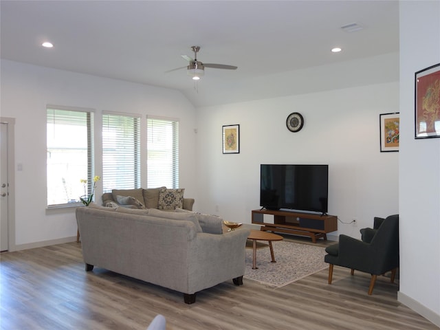 living room with recessed lighting, light wood-type flooring, lofted ceiling, and visible vents