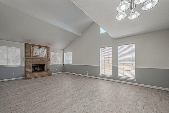 unfurnished living room featuring beamed ceiling, baseboards, a brick fireplace, and wood finished floors