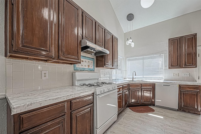 kitchen featuring under cabinet range hood, white appliances, dark brown cabinets, and a sink