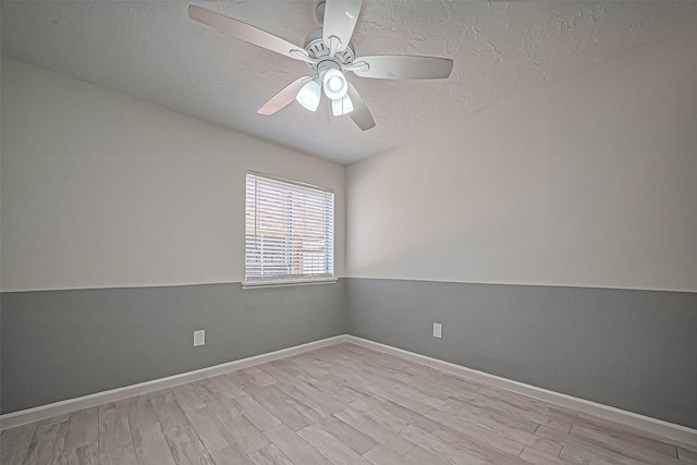 spare room featuring baseboards, light wood-style flooring, a textured ceiling, and a ceiling fan