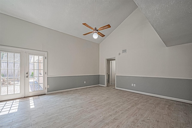 unfurnished living room with wood finished floors, visible vents, french doors, and a textured ceiling