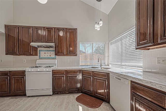 kitchen with under cabinet range hood, a sink, white appliances, light wood finished floors, and light countertops