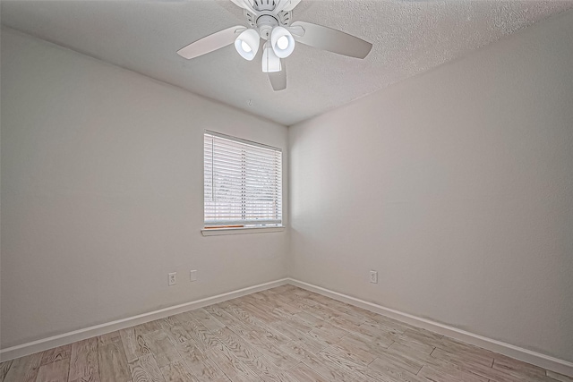 unfurnished room featuring ceiling fan, baseboards, a textured ceiling, and light wood-style flooring