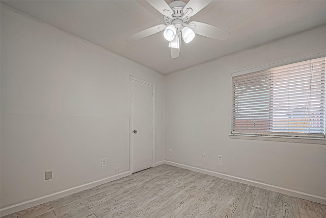 empty room with baseboards, light wood finished floors, and ceiling fan