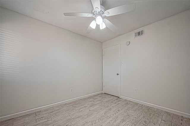 empty room featuring visible vents, ceiling fan, baseboards, and light wood-style floors