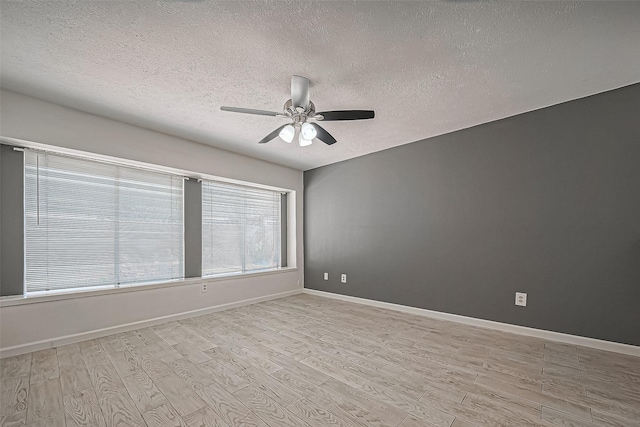 unfurnished room featuring baseboards, light wood-style floors, ceiling fan, and a textured ceiling