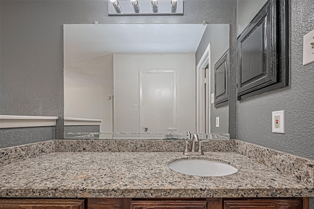 bathroom with vanity and a textured wall