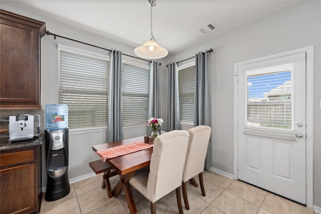 dining area featuring light tile patterned floors, visible vents, and baseboards