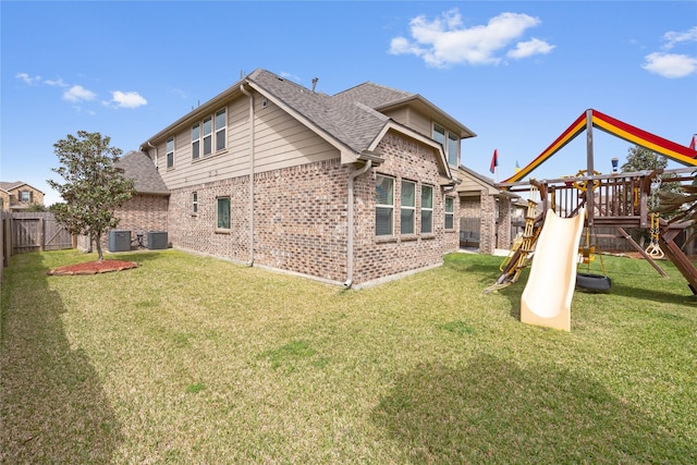 back of property with a playground, cooling unit, a fenced backyard, and brick siding