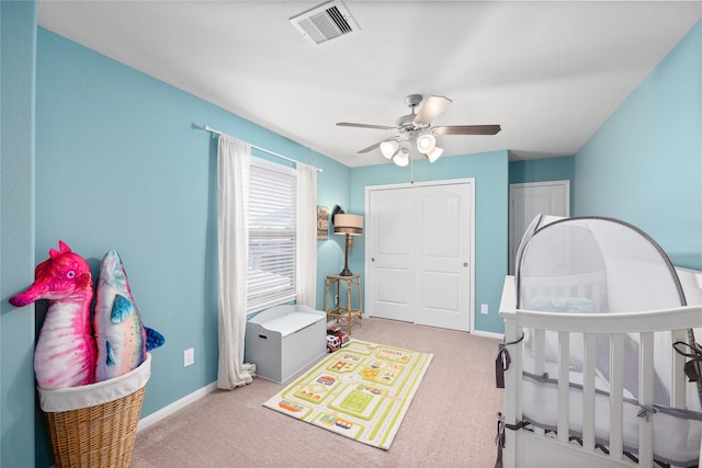 carpeted bedroom with visible vents, baseboards, a closet, and a ceiling fan