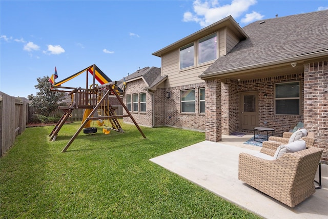 back of house featuring a lawn, a fenced backyard, a playground, brick siding, and a patio area