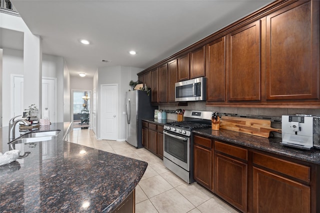 kitchen featuring visible vents, a sink, tasteful backsplash, stainless steel appliances, and light tile patterned flooring