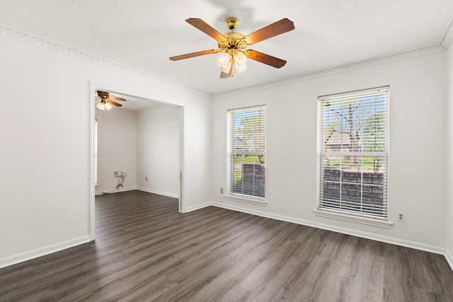 spare room with crown molding, dark wood-style floors, and a healthy amount of sunlight