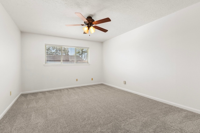 spare room with light carpet, a textured ceiling, baseboards, and a ceiling fan