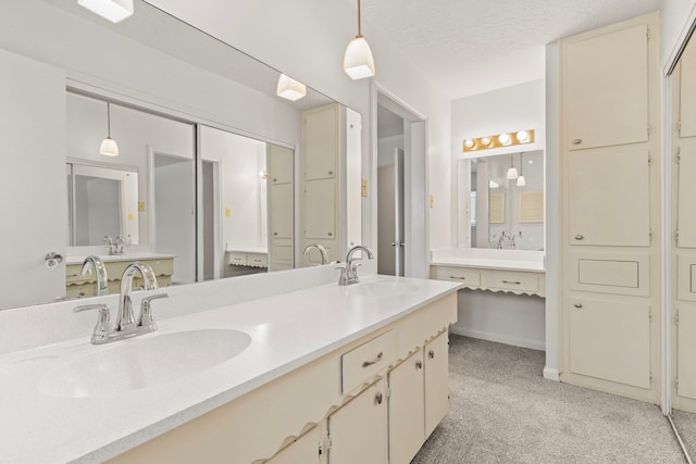 full bathroom with a textured ceiling, double vanity, carpet, and a sink