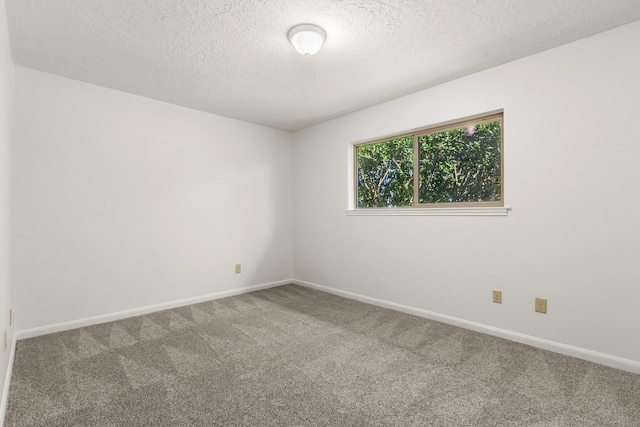 carpeted empty room with baseboards and a textured ceiling