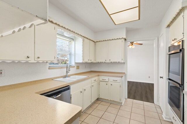 kitchen with light tile patterned floors, ceiling fan, stainless steel appliances, light countertops, and a sink