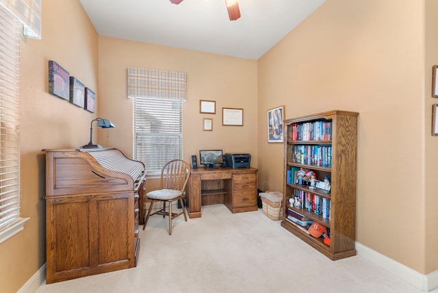 carpeted office space featuring baseboards and ceiling fan