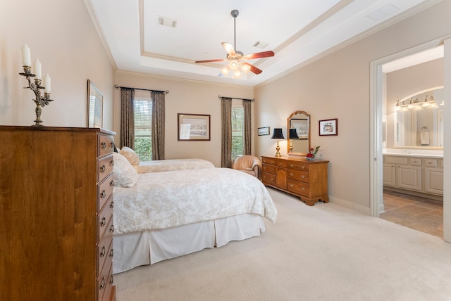 bedroom featuring visible vents, a tray ceiling, carpet flooring, crown molding, and baseboards